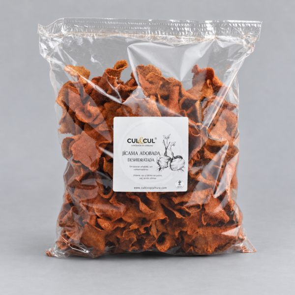 Bolsa grande de chips de jícama adobada deshidratada con etiqueta frontal sobre fondo gris claro.
