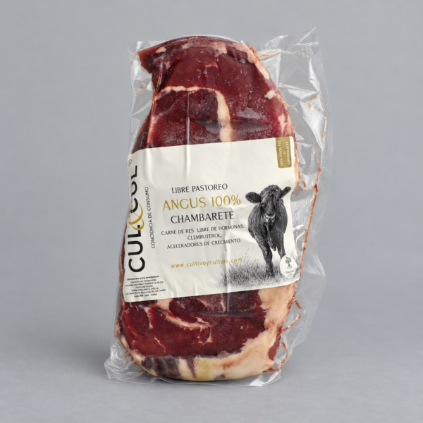 Chambarete de res Angus sin hueso empacado al vacío sobre fondo gris neutro.