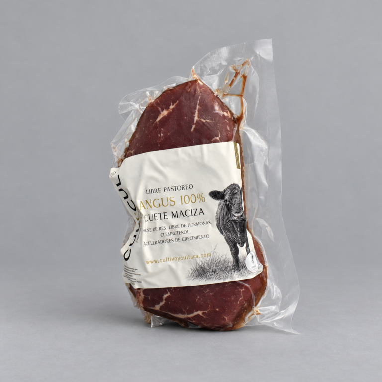 Cuete maciza de res Angus empacado al vacío sobre fondo gris neutro.