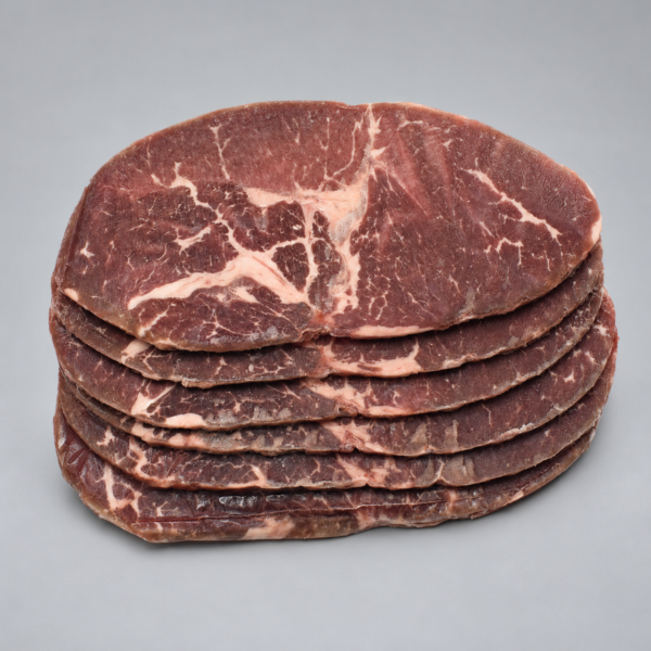 Bisteces de Vampiro de Sirloin apilados, con vetas de grasa visibles sobre fondo gris.